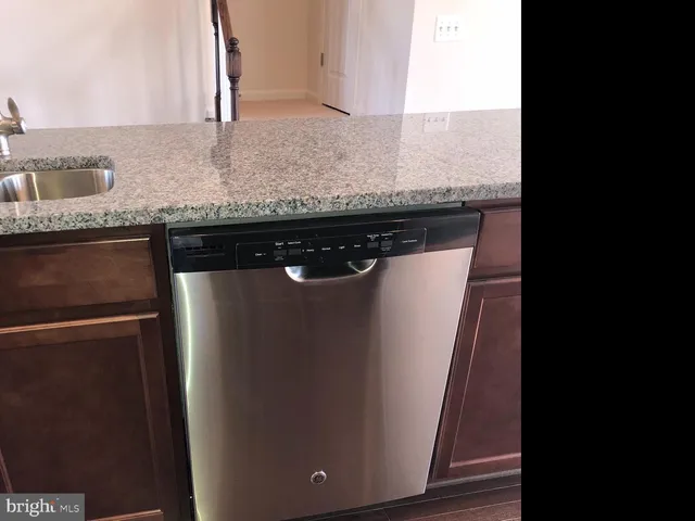 a close view of a granite counter top a sink and a dishwasher