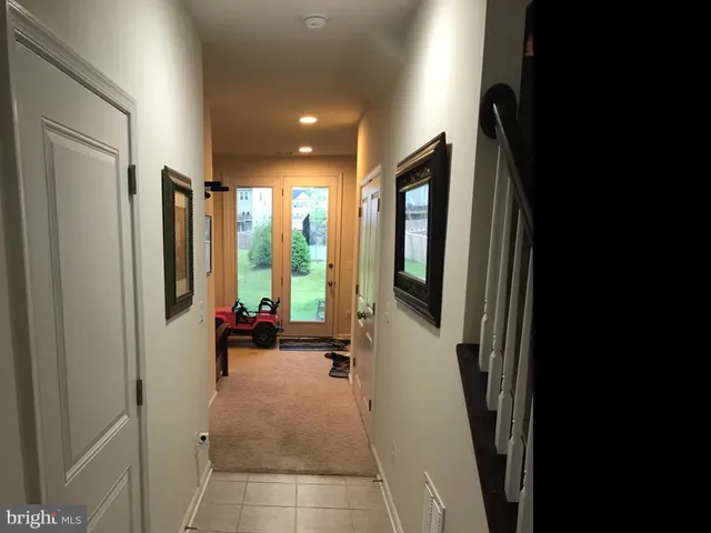 a hallway with large windows and furniture