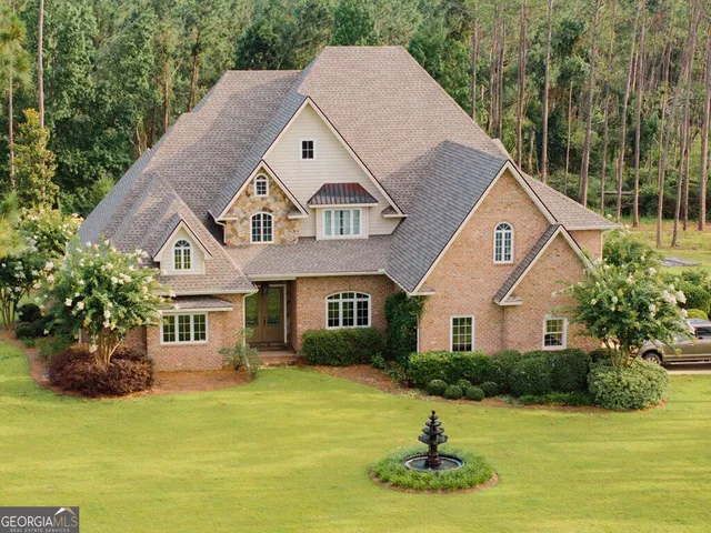 a front view of a house with a yard garage and trees