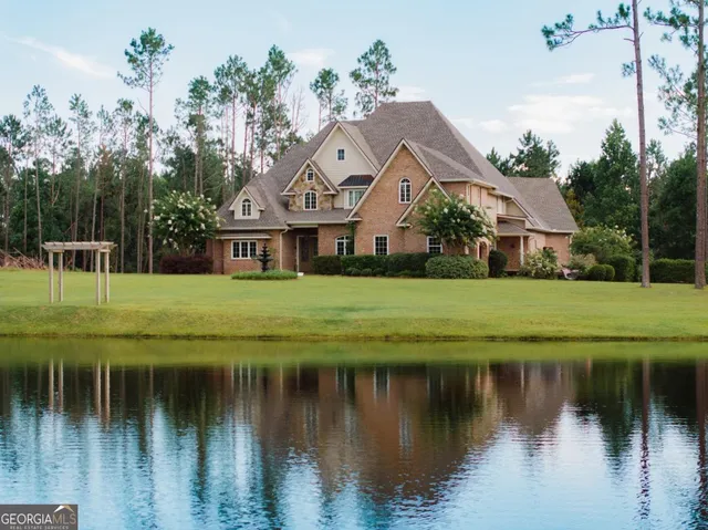 a view of house with garden and tall trees