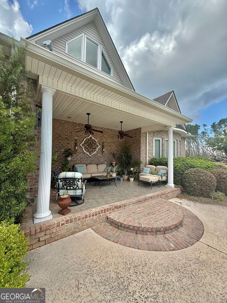 3 Chestnut Road Hazlehurst, GA 31539 - Photo 55 of 66 a view of a white house with large windows and a table and chairs in front of it