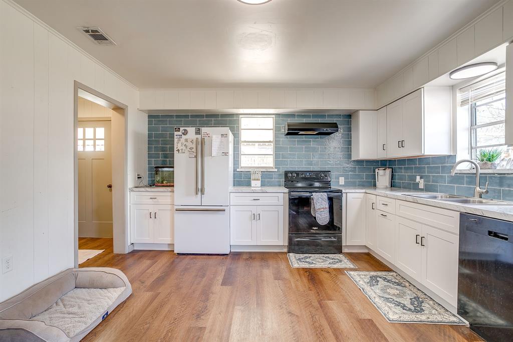 610 North Mesquite Hico, TX 76457 - Photo 15 of 34 Kitchen featuring white cabinets, black appliances, and light wood-style floors