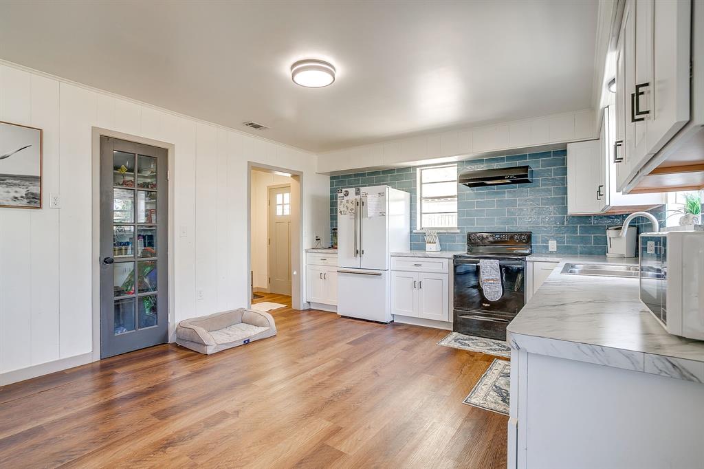 610 North Mesquite Hico, TX 76457 - Photo 16 of 34 Kitchen featuring light countertops, black range with electric cooktop, high end white refrigerator, white cabinets, and tasteful backsplash