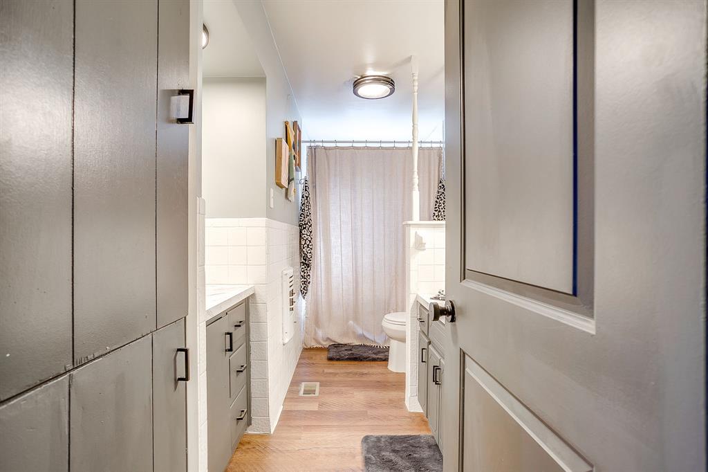 610 North Mesquite Hico, TX 76457 - Photo 23 of 34 Bathroom with vanity, light wood-style flooring, and tile walls