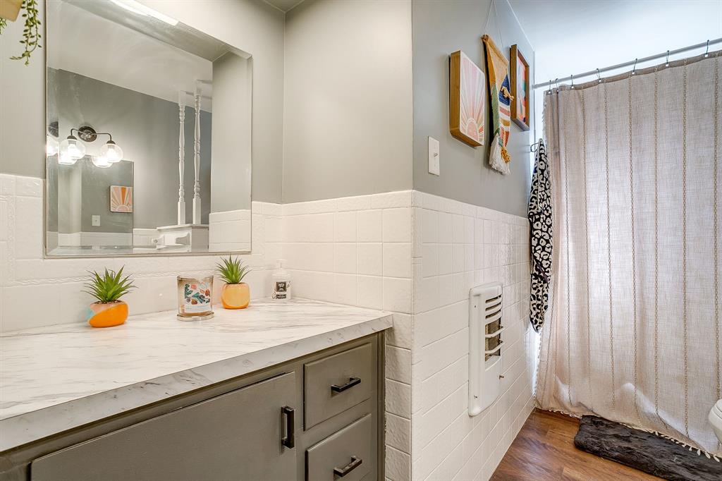 610 North Mesquite Hico, TX 76457 - Photo 25 of 34 Bathroom with vanity, dark wood-style flooring, a wainscoted wall, tile walls, and heating unit