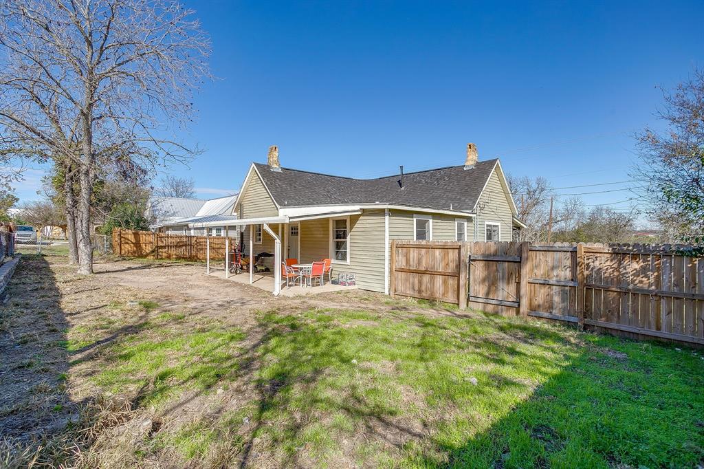 610 North Mesquite Hico, TX 76457 - Photo 29 of 34 Rear view of house featuring a patio area, a fenced backyard, roof with shingles, and a gate