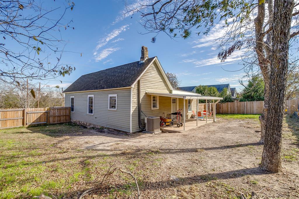 610 North Mesquite Hico, TX 76457 - Photo 30 of 34 Back of house featuring a patio area, a fenced backyard, a shingled roof, and a gate