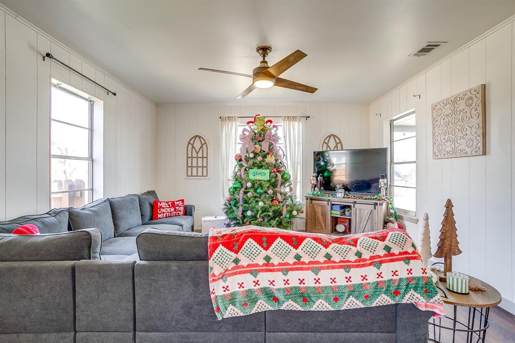 610 North Mesquite Hico, TX 76457 - Photo 6 of 34 Living area with ceiling fan and wood walls