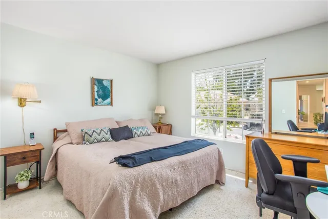 a bedroom with a bed a large window and a couch