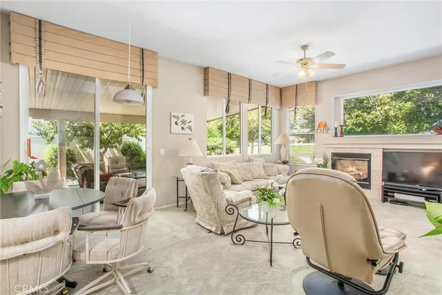 a living room with furniture a fireplace and a large window