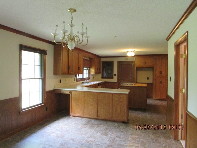 5835 Huddersfield Road Macon, GA 31210 - Photo 11 of 19 a large kitchen with kitchen island granite countertop a sink a stove and a window