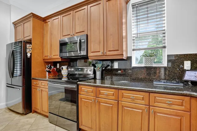 a kitchen with stainless steel appliances granite countertop a refrigerator and a sink