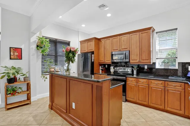 a kitchen with stainless steel appliances granite countertop a sink and a stove