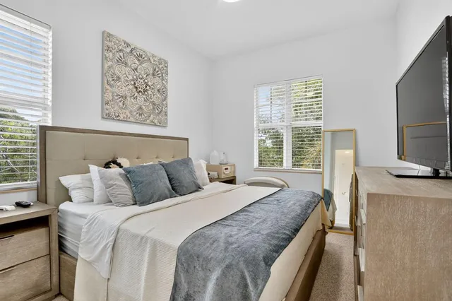 a bedroom with a large bed and a flat tv screen on dresser