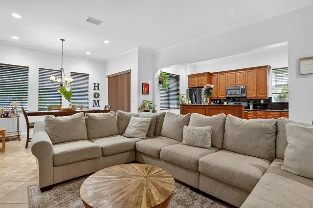 a living room with furniture kitchen view and a large window