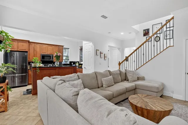 a living room with furniture kitchen view and a potted plant