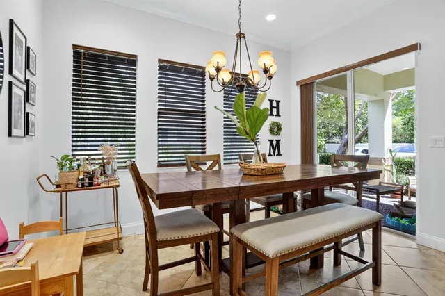 a dining room with furniture a chandelier and window