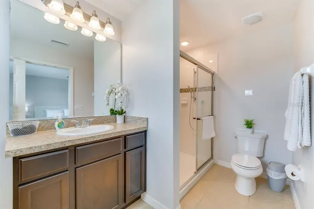 a bathroom with a granite countertop toilet sink and mirror