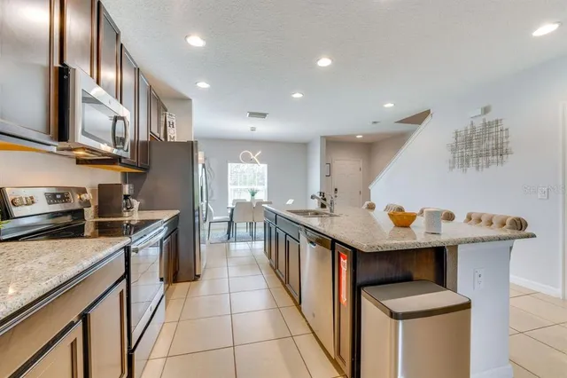 a kitchen with stainless steel appliances granite countertop a sink counter space and wooden floor