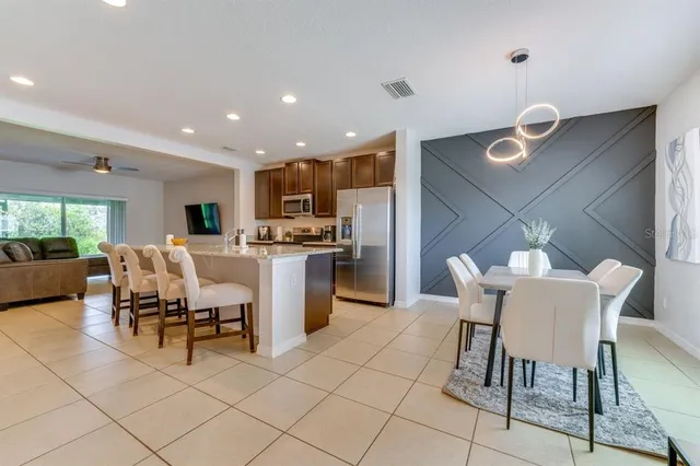 a kitchen with a table chairs and a refrigerator