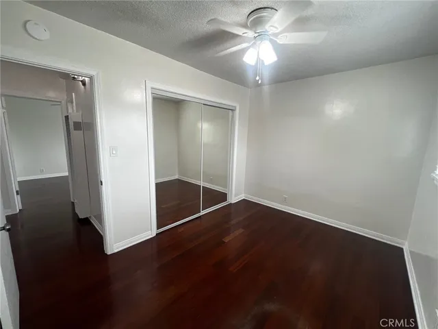 an empty room with wooden floor and closet