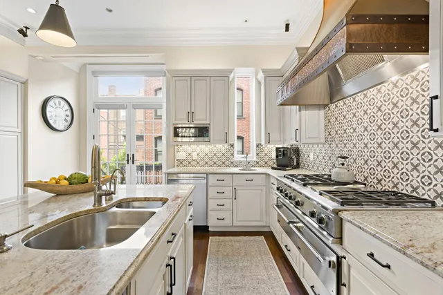 a kitchen with granite countertop a sink stove and cabinets