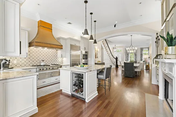 a kitchen with stainless steel appliances a stove a sink dishwasher and white cabinets with wooden floor