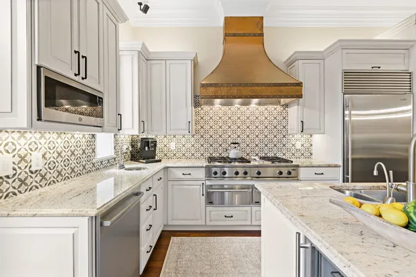 a kitchen with stainless steel appliances granite countertop a sink stove and cabinets