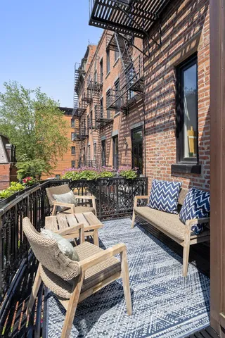 a view of a patio with couches table and chairs and wooden floor