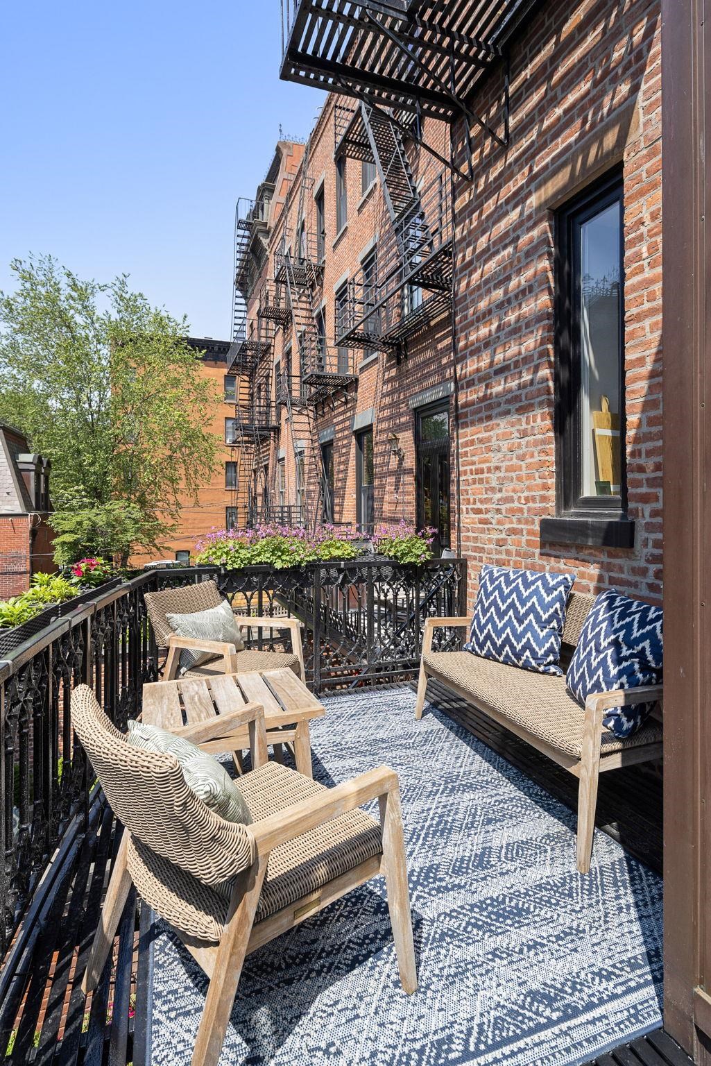 630 Hudson Street Hoboken, NJ 07030 - Photo 17 of 50 a view of a patio with couches table and chairs and wooden floor