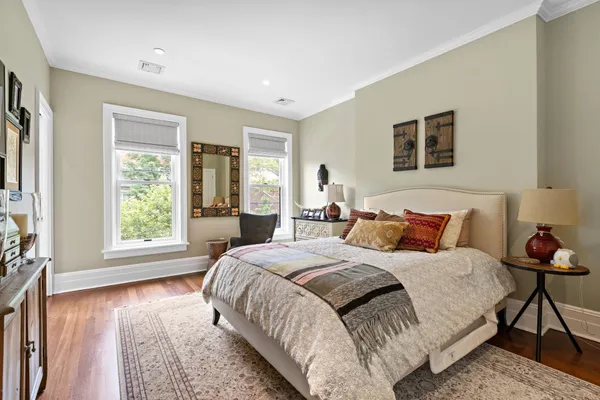 a bedroom with a bed and wooden floor