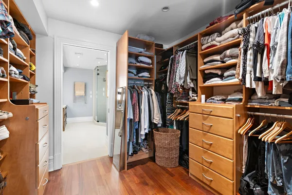 a view of walk in closet with clothes and shoes