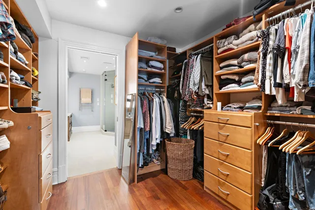 a view of walk in closet with clothes and shoes