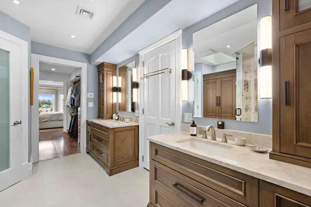 a spacious bathroom with a double vanity sink a mirror and a bathtub