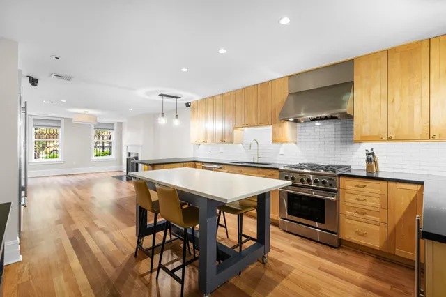 a kitchen with a stove a sink a refrigerator and wooden floor