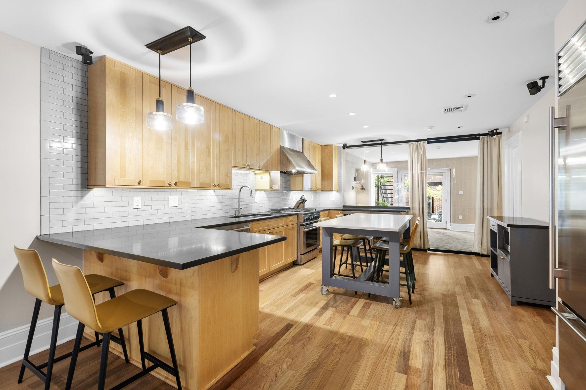630 Hudson Street Hoboken, NJ 07030 - Photo 43 of 50 a kitchen with a table chairs refrigerator and wooden floor