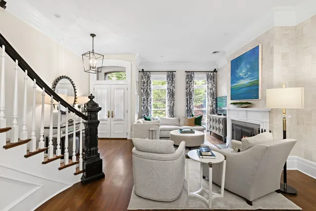 a living room with furniture a fireplace and a chandelier