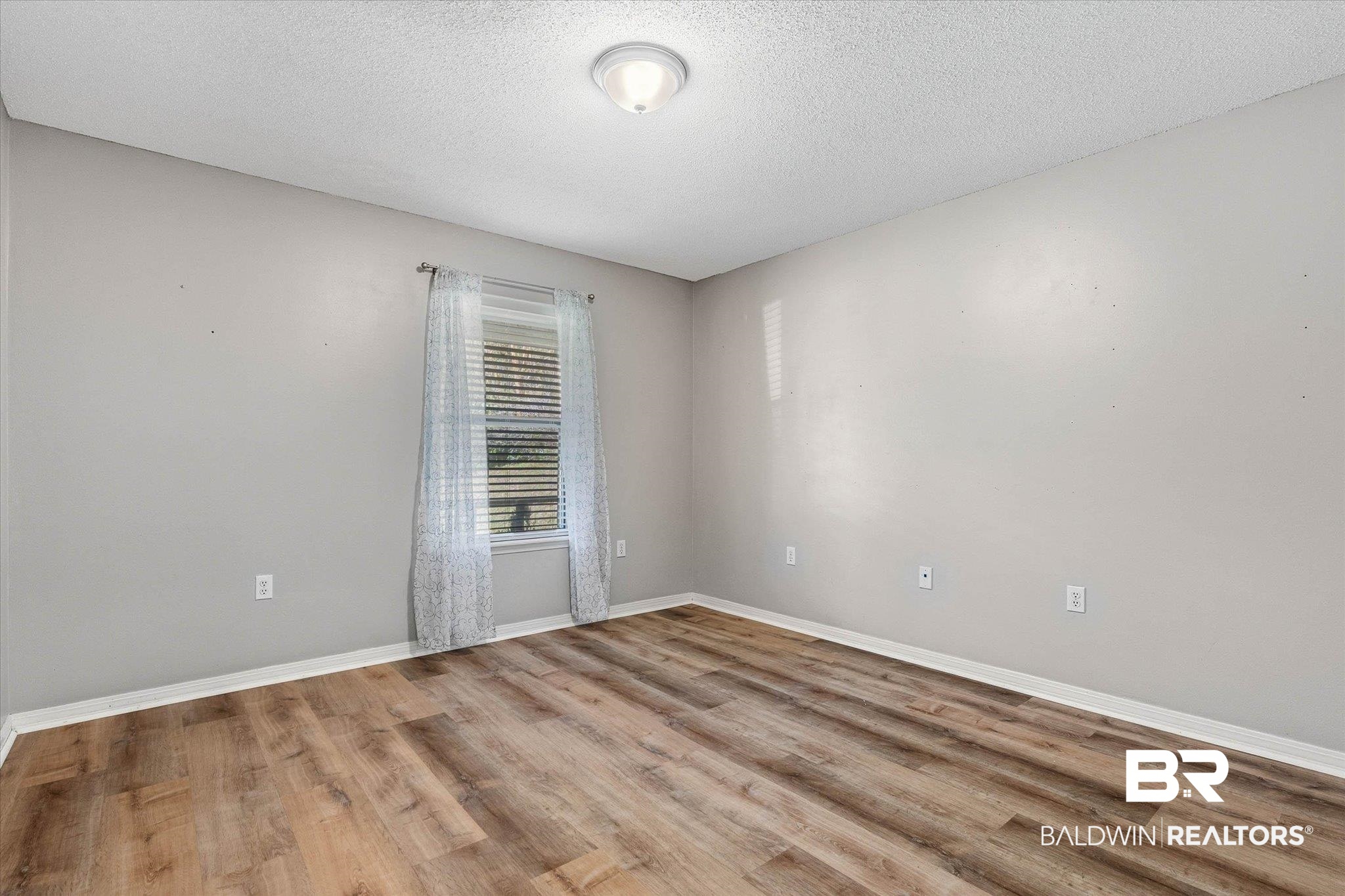 8030 Country Drive Mobile, AL 36619 - Photo 14 of 22 Empty room featuring light wood-style flooring and a textured ceiling