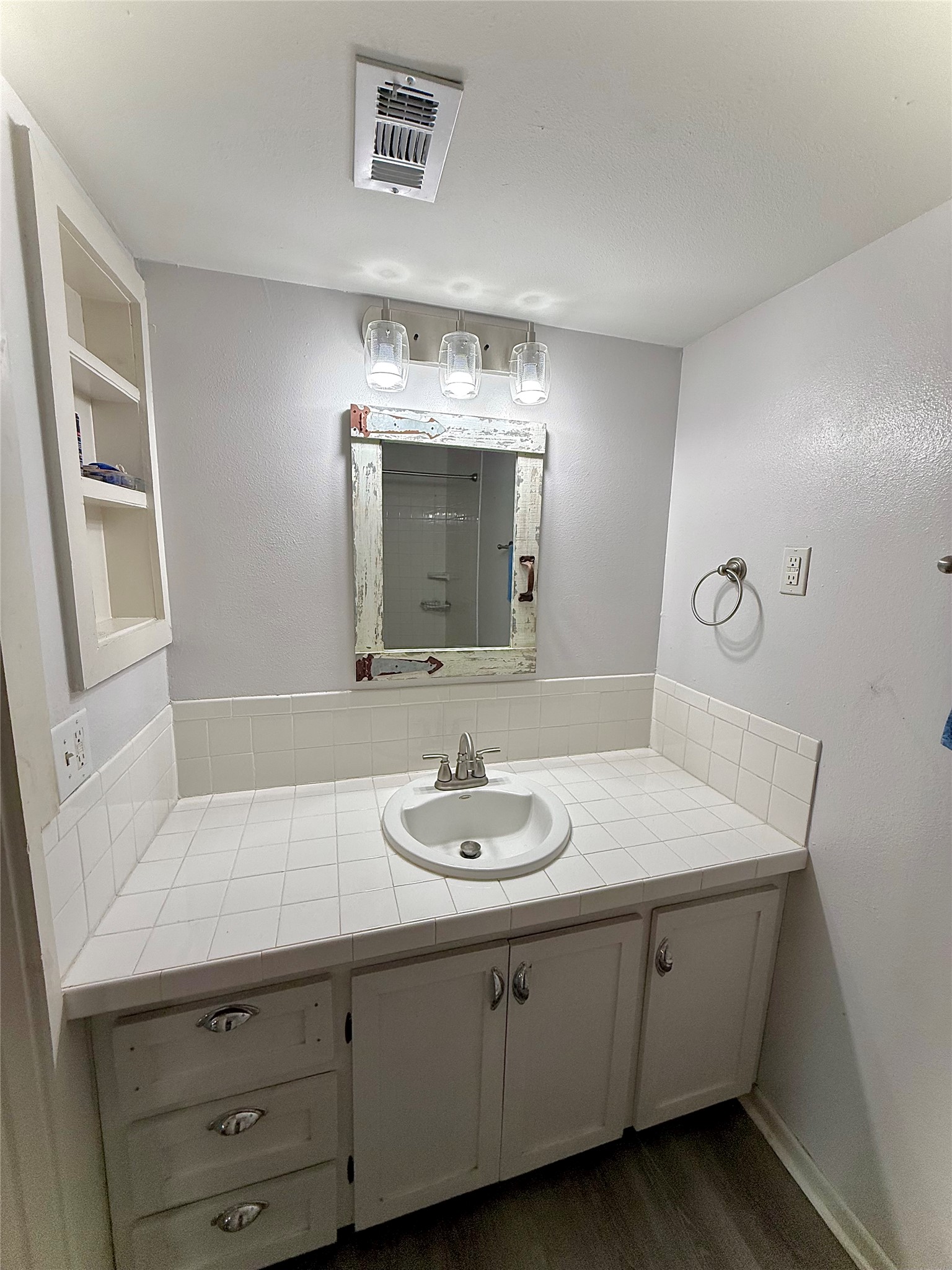 423 South Main Street Lockhart, TX 78644 - Photo 11 of 26 Bathroom vanity featuring a drop-in sink with a chrome faucet, set into a tiled countertop with a matching tiled backsplash