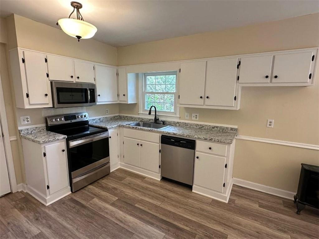121 Hunt Drive Calhoun, GA 30701 - Photo 7 of 20 a kitchen with granite countertop a stove a sink and a microwave