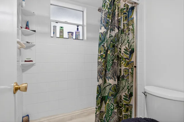 a bathroom with a shower curtain and a toilet