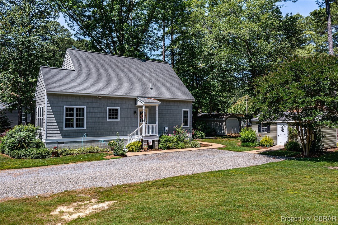 189 Virginia Road Reedville, VA 22539 - Photo 34 of 46 View of front facade featuring a front yard, an outdoor structure, a shingled roof, and driveway
