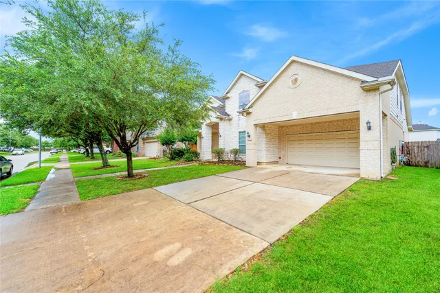 a view of a house with a yard and large tree