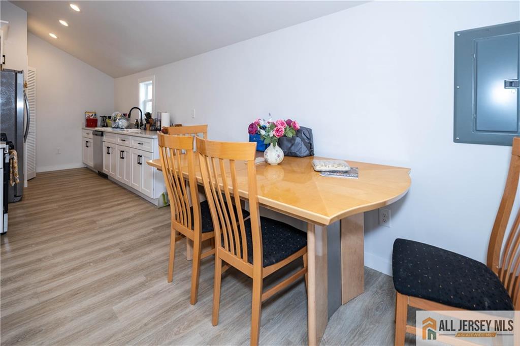 27 South 2nd Street Fords, NJ 08863 - Photo 25 of 33 a kitchen with stainless steel appliances kitchen island a table chairs in it and wooden floors