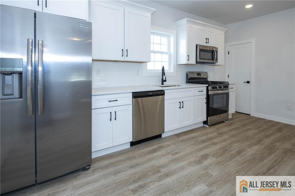 27 South 2nd Street Fords, NJ 08863 - Photo 9 of 33 a kitchen with cabinets stainless steel appliances and wooden floor
