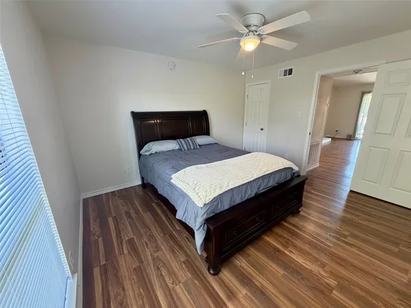 a bedroom with a bed and closet with wooden floor