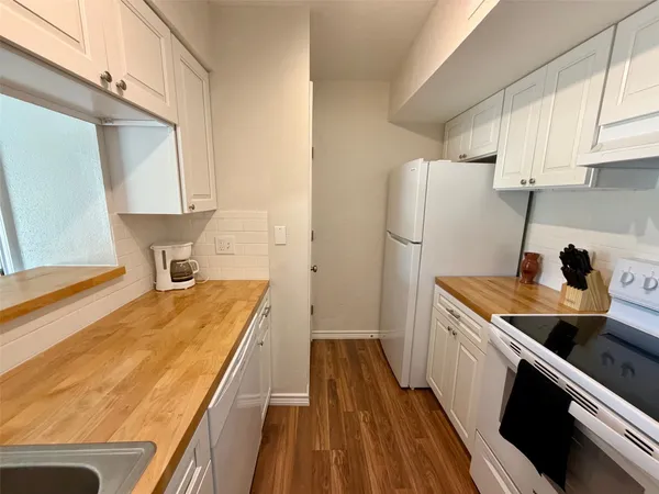 a kitchen with a sink a refrigerator and cabinets