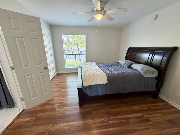 a bedroom with a bed and wooden floor