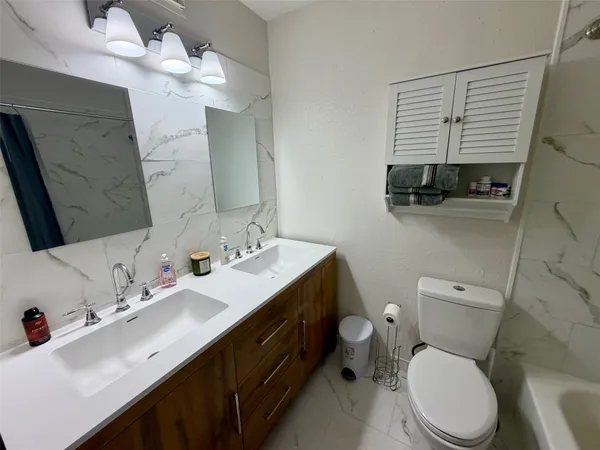 a bathroom with a sink a toilet and a mirror