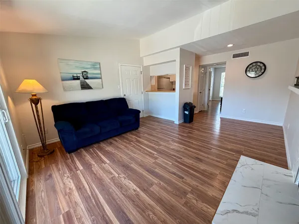 a living room with a bed furniture and a wooden floor